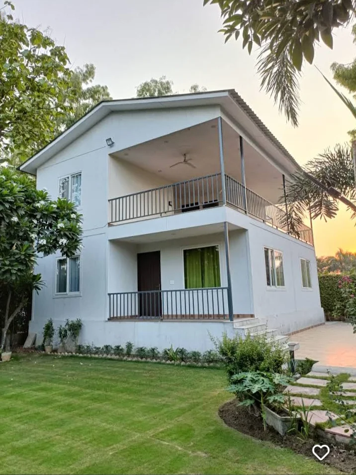HK Farm House Noida exterior at sunset — two storey farmhouse with balcony in Sector 150